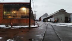 Revisiting this classic strip district scene with mixed artificial/natural light, rail road tracks, warehouses, rust, wet pavement, and reflections.